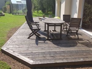 Terrasse en pin traité gris foncé.