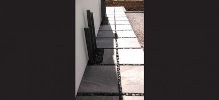 Passage en dalles de grès cérame et joints de galets noirs Passage en dalles de grès cérame et joints de galets noirs